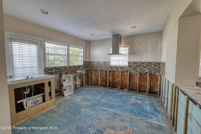 kitchen featuring wall chimney range hood