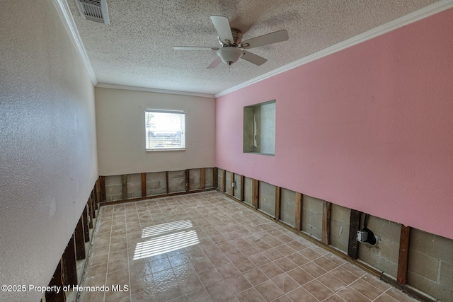 empty room featuring ceiling fan, ornamental molding, and a textured ceiling