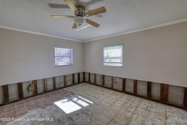 empty room with plenty of natural light, ceiling fan, and a textured ceiling