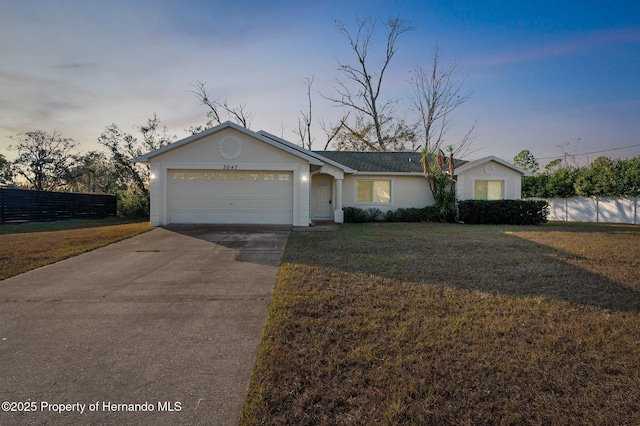 ranch-style home with a garage and a yard