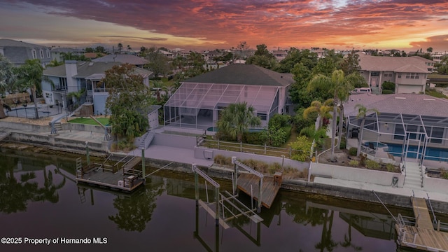 aerial view at dusk featuring a water view