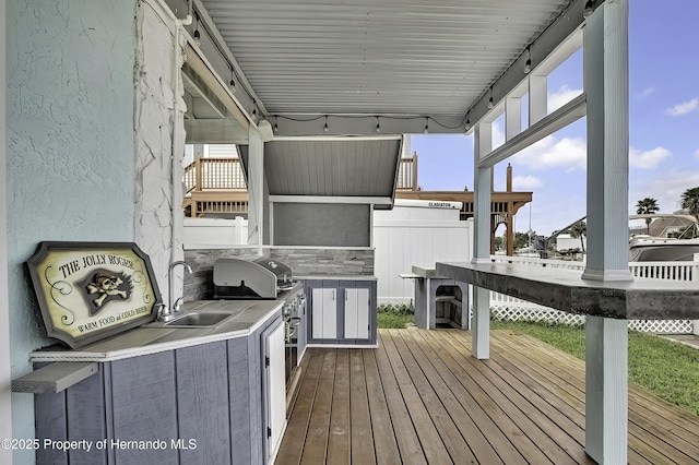 wooden terrace featuring sink, area for grilling, and an outdoor kitchen