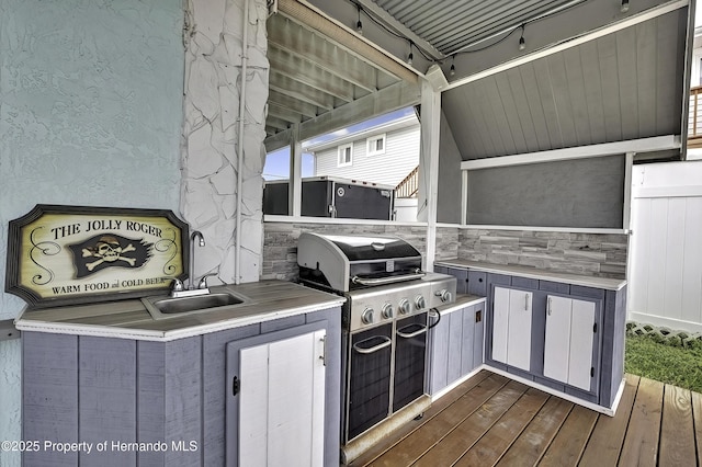 view of patio with sink, a deck, exterior kitchen, and grilling area