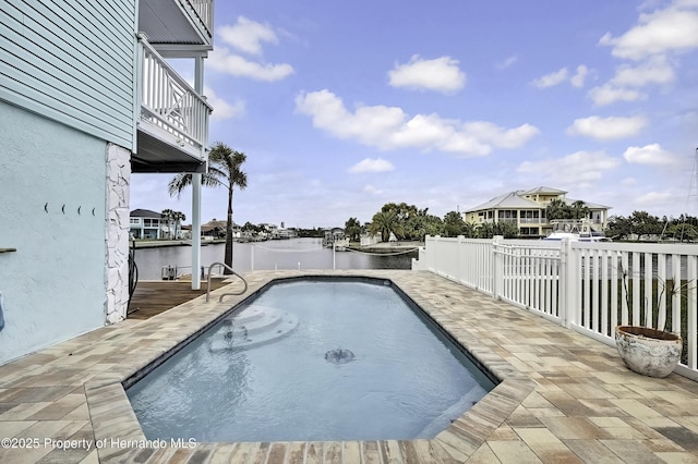 view of swimming pool featuring a water view and a patio area