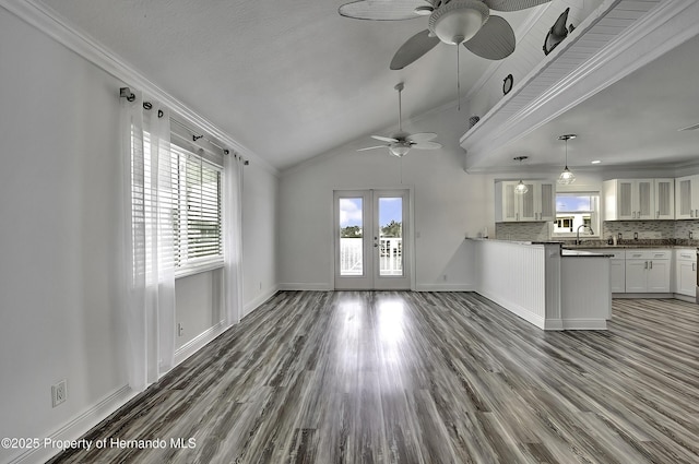 kitchen with ornamental molding, vaulted ceiling, backsplash, and white cabinetry