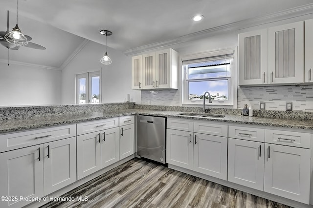 kitchen with sink, white cabinets, decorative light fixtures, lofted ceiling, and stainless steel dishwasher