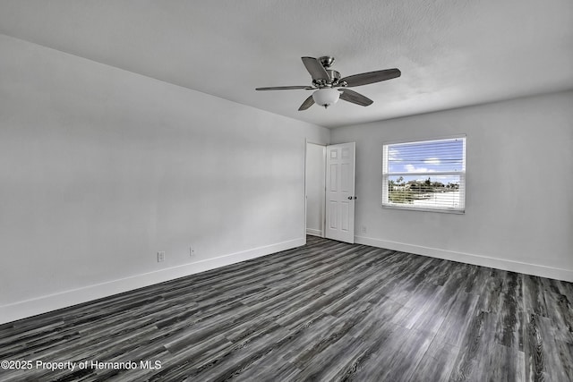 spare room with dark hardwood / wood-style flooring and ceiling fan