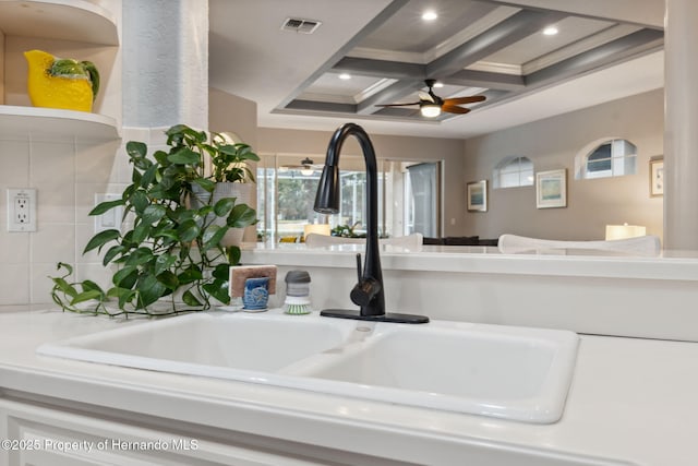 details with coffered ceiling, beamed ceiling, ceiling fan, ornamental molding, and sink