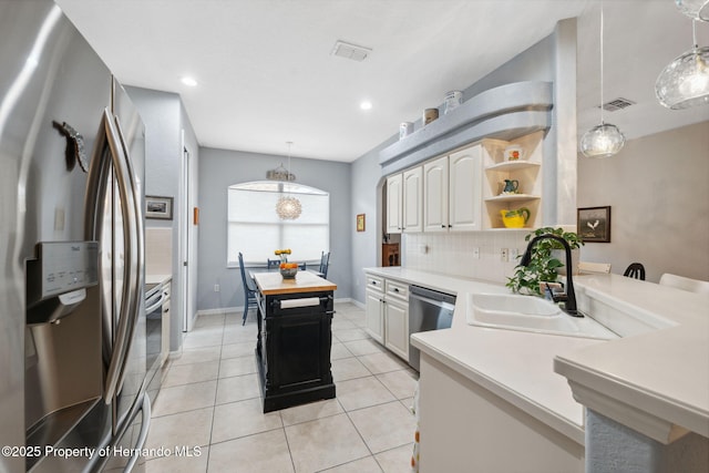 kitchen featuring stainless steel appliances, sink, decorative light fixtures, light tile patterned floors, and tasteful backsplash