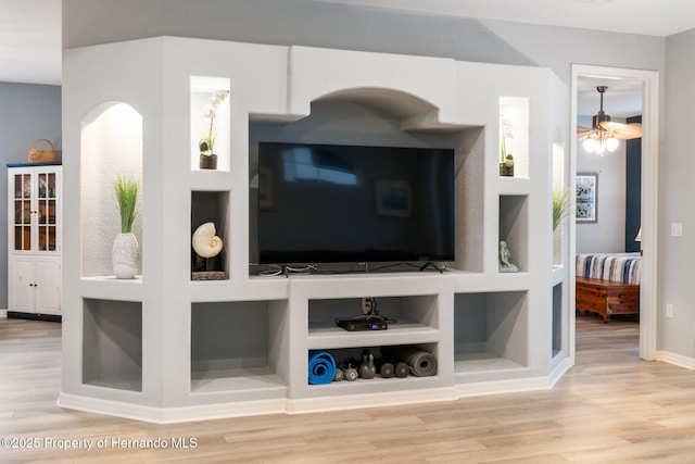 living room featuring built in shelves and wood-type flooring