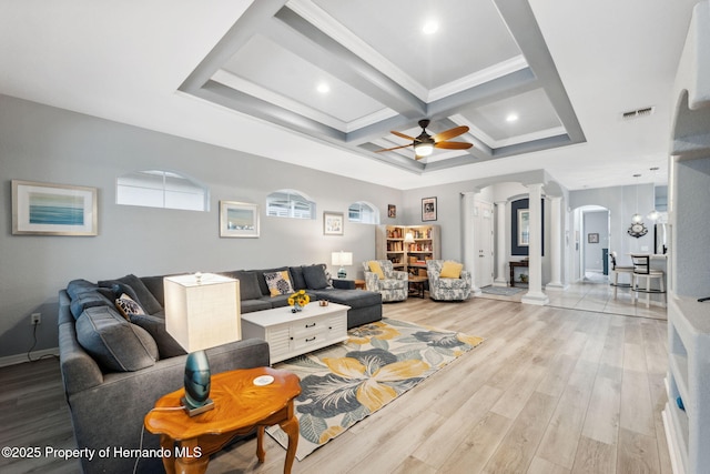 living room with coffered ceiling, beam ceiling, light hardwood / wood-style flooring, decorative columns, and ceiling fan with notable chandelier