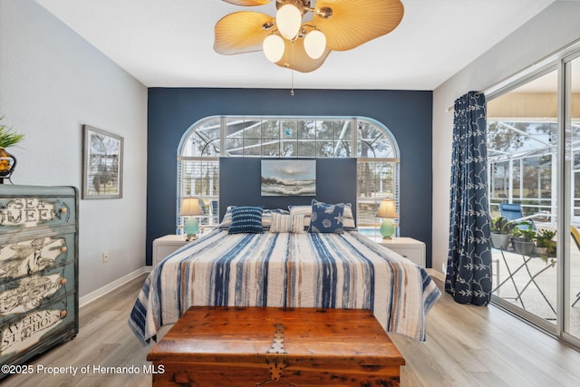 bedroom featuring ceiling fan, light hardwood / wood-style flooring, access to exterior, and multiple windows