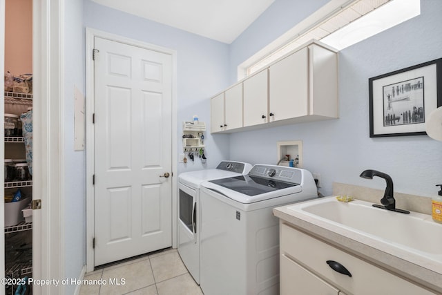 washroom featuring separate washer and dryer, cabinets, sink, and light tile patterned floors