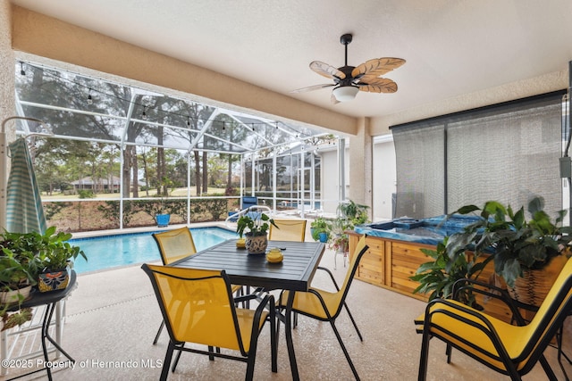 sunroom featuring ceiling fan and a pool