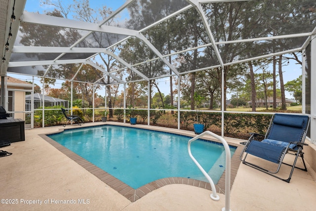 view of swimming pool featuring a lanai and a patio area