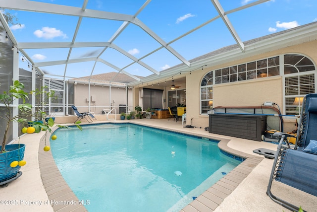 view of swimming pool with a lanai, ceiling fan, and a patio