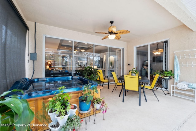 sunroom with ceiling fan and a hot tub