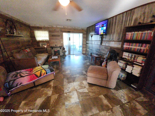 living room featuring wood walls and ceiling fan