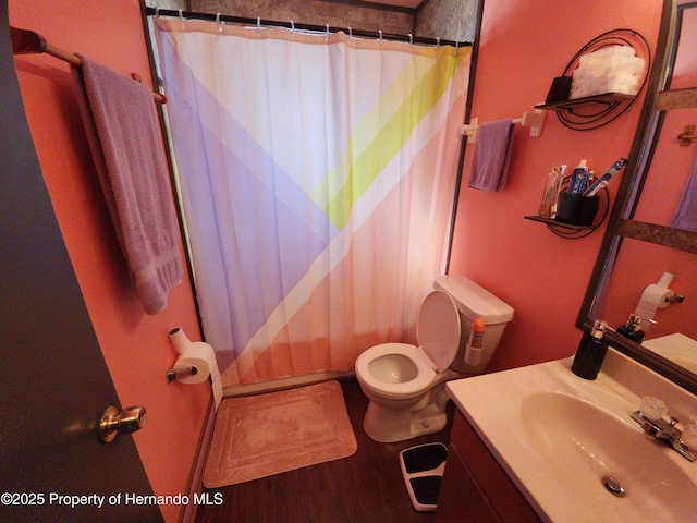 bathroom with a shower with shower curtain, vanity, toilet, and wood-type flooring