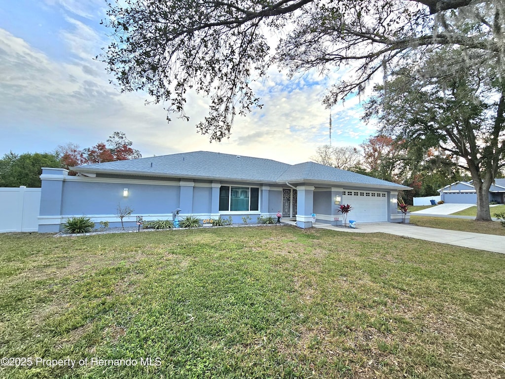 ranch-style home with a front lawn and a garage