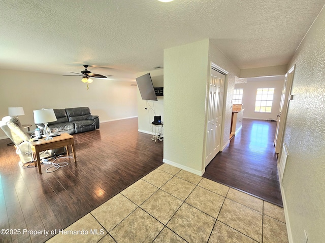 interior space featuring ceiling fan, tile patterned flooring, and a textured ceiling