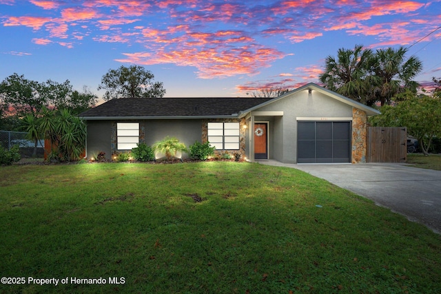 single story home featuring a yard and a garage