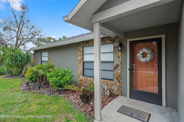 view of exterior entry with a yard