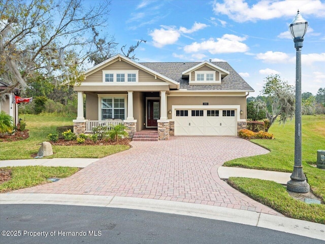 craftsman-style house featuring a porch, a front yard, and a garage