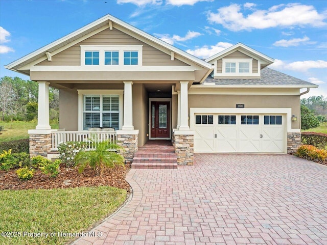 craftsman house featuring covered porch and a garage