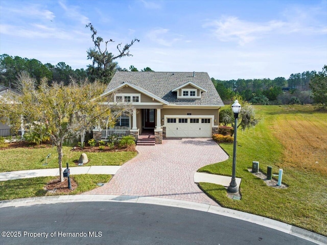 craftsman-style house with covered porch, a front lawn, and a garage