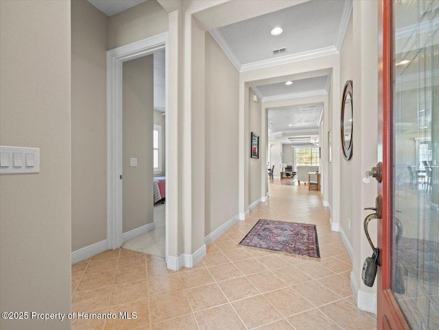 hall with ornamental molding and light tile patterned floors