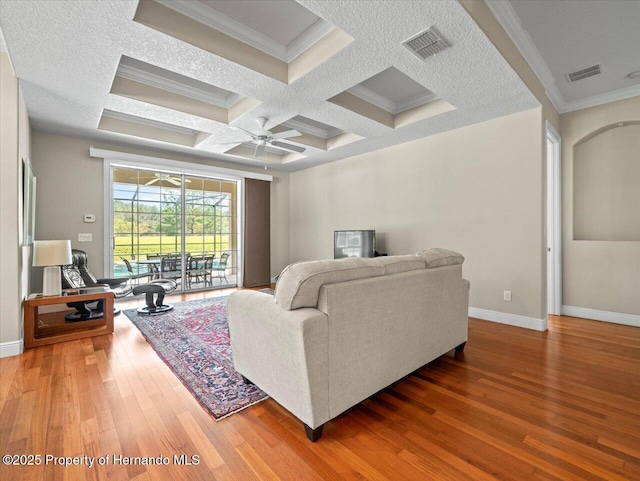 living room with ceiling fan, coffered ceiling, hardwood / wood-style floors, and beamed ceiling