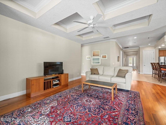 living room with coffered ceiling and crown molding