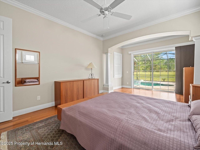 bedroom with a textured ceiling, access to exterior, hardwood / wood-style floors, ceiling fan, and ornamental molding