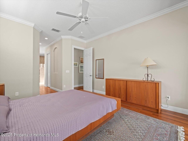 bedroom with wood-type flooring, a textured ceiling, ceiling fan, and crown molding