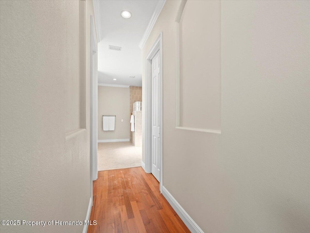 corridor featuring ornamental molding and hardwood / wood-style floors