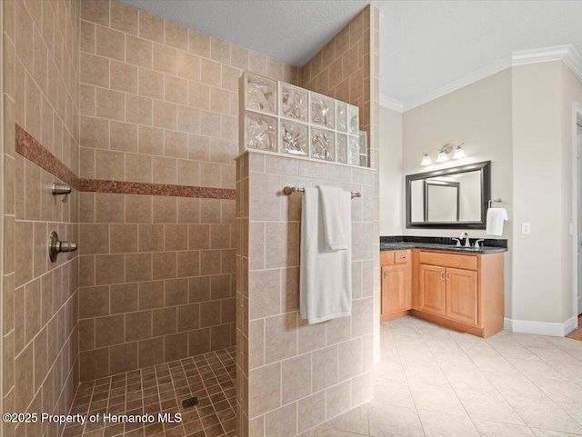 bathroom with a tile shower, vanity, tile patterned floors, and ornamental molding