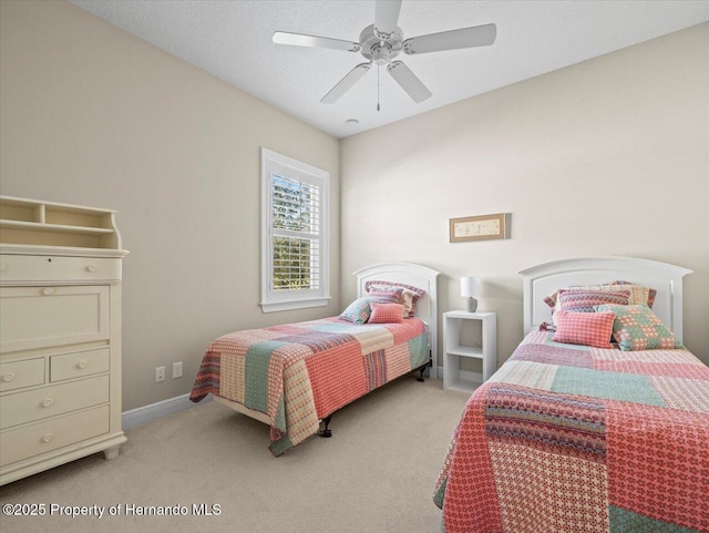 bedroom with a textured ceiling, ceiling fan, and light colored carpet