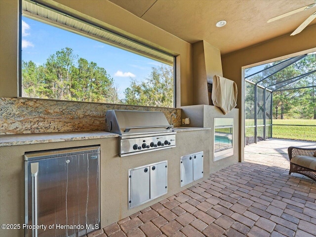 view of patio / terrace with exterior kitchen, sink, a lanai, and area for grilling