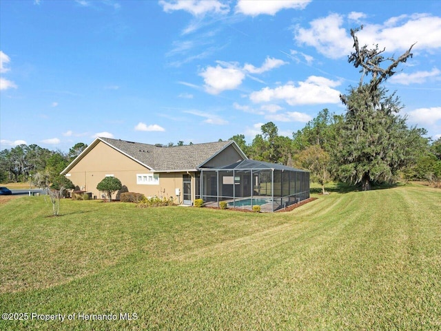 back of house with a yard and glass enclosure