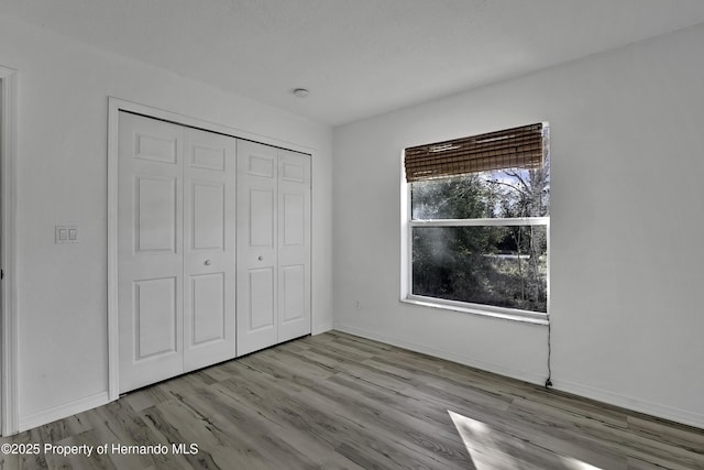 unfurnished bedroom with light hardwood / wood-style floors and a closet