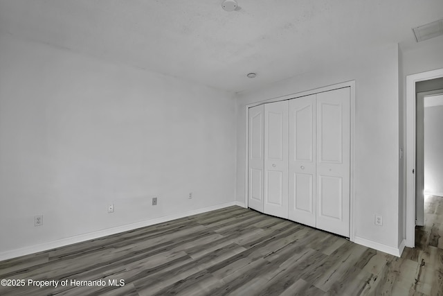 unfurnished bedroom featuring a closet and hardwood / wood-style floors