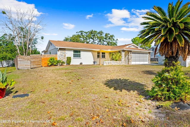 single story home with a garage and a front lawn