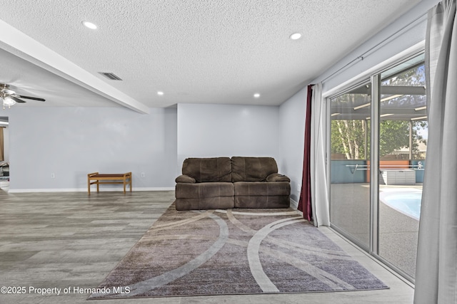 sitting room featuring a textured ceiling, ceiling fan, beam ceiling, and light hardwood / wood-style floors