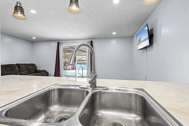 room details featuring light stone countertops, sink, a textured ceiling, and a jacuzzi