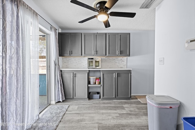 washroom featuring ceiling fan, a textured ceiling, and light hardwood / wood-style flooring