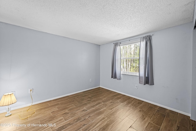 unfurnished room with a textured ceiling