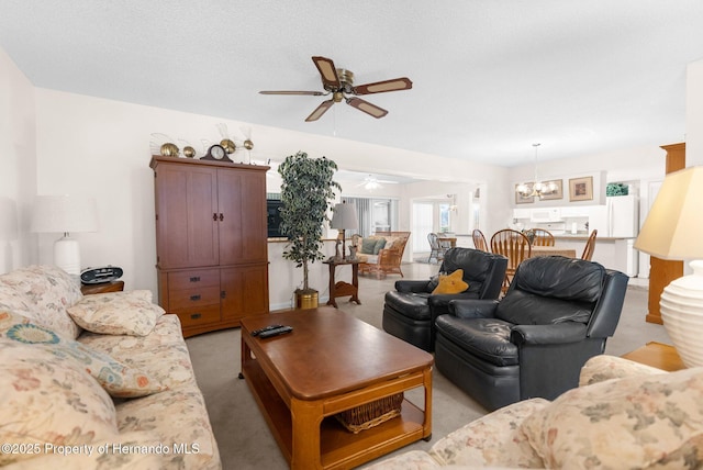 carpeted living room featuring ceiling fan with notable chandelier