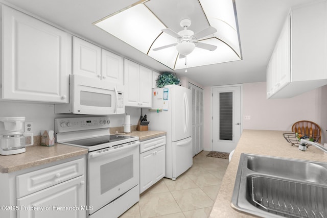 kitchen with sink, white appliances, light tile patterned floors, ceiling fan, and white cabinets