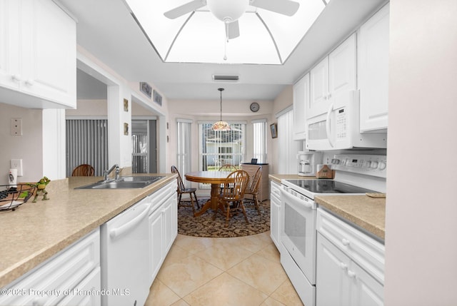 kitchen with white appliances, sink, hanging light fixtures, and white cabinets